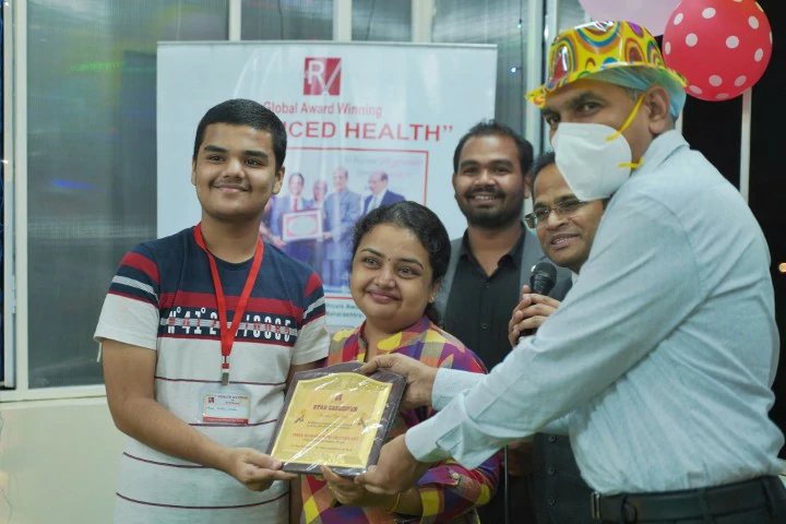Dr. Ravi Vairagade felicitating a family at an Advanced Health event